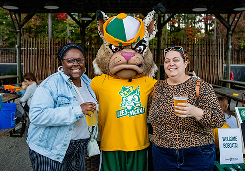 Alumni posing with the Lees-McRae mascot at a social event