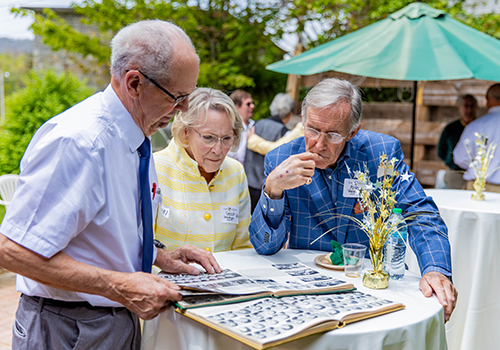 Alumni looking through a yearbook together at a reunion event