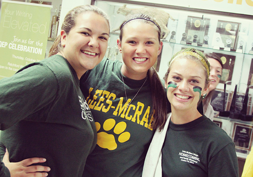 Students smiling together during a campus event wearing Lees-McRae apparel