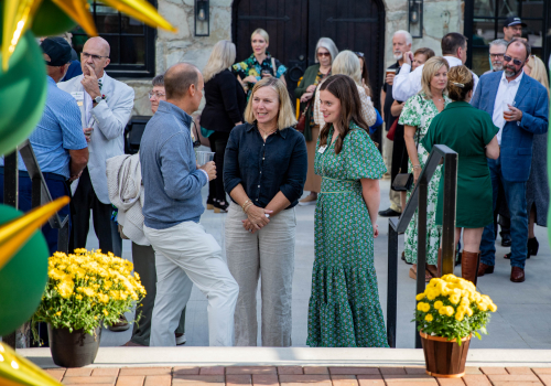 Groups of people conversing at an outdoor event.